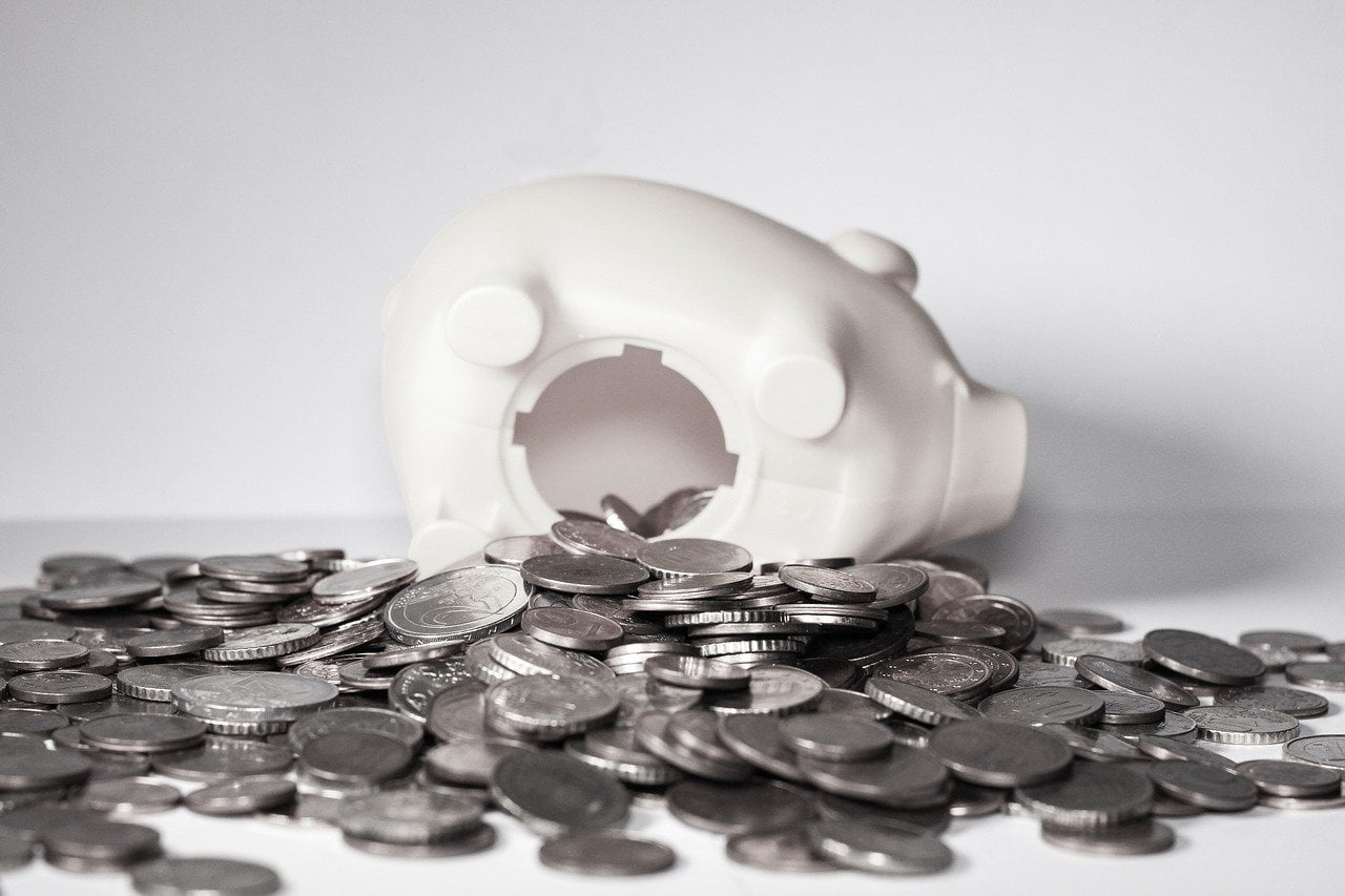 a white plastic toy on a pile of coins