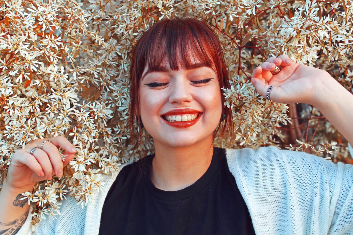 a person smiling with the hands on the head