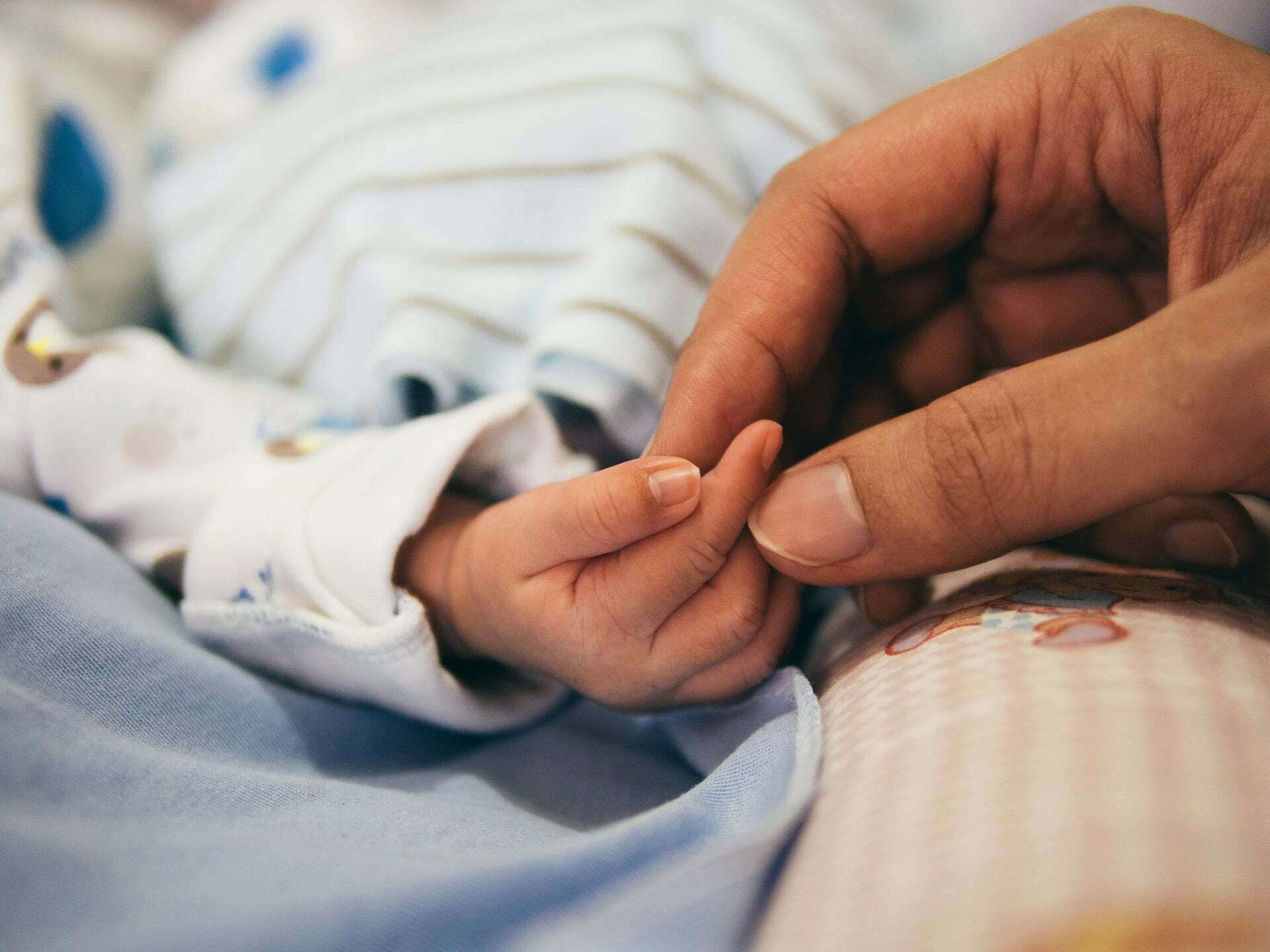 a person holding a needle to a baby's foot