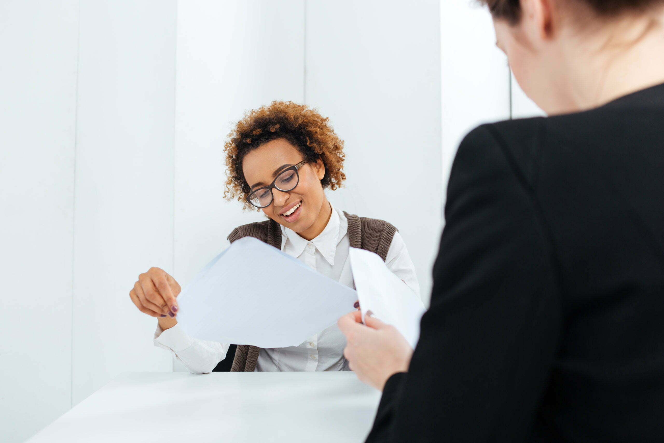 a woman showing a man something on the paper