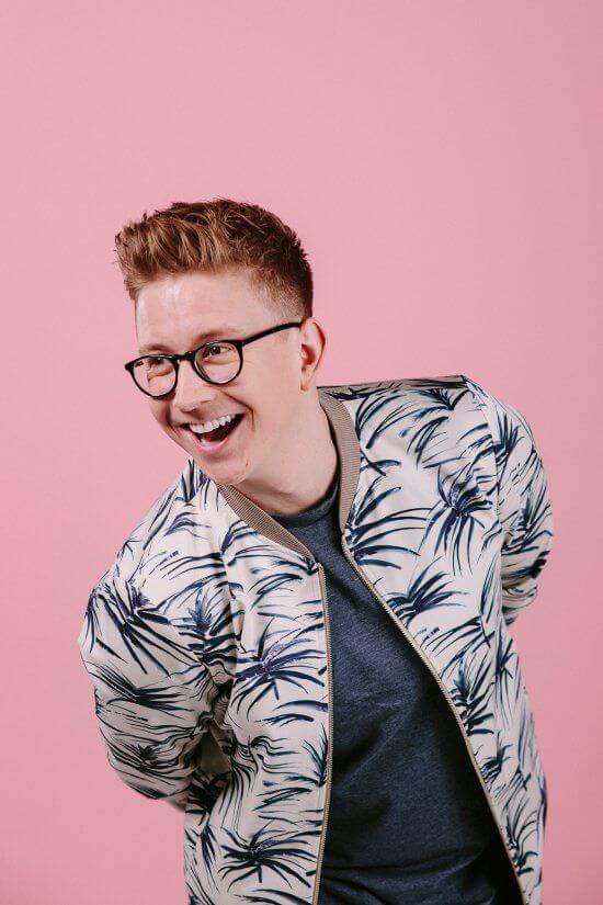 Tyler Oakley with glasses smiling