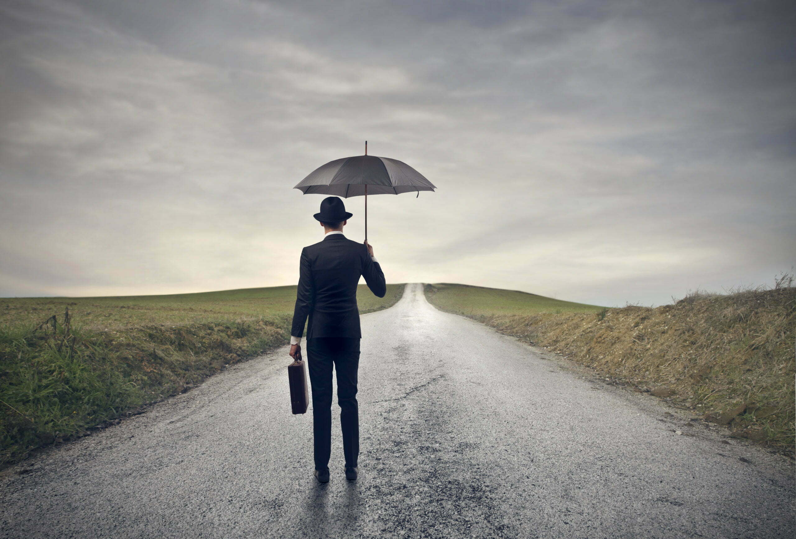 a man holding an umbrella on a road